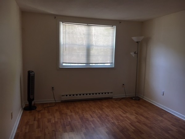 80 Leonard Road, Unit 80 Boxborough, MA 01719 - Photo 4 of 6 an empty room with wooden floor and windows