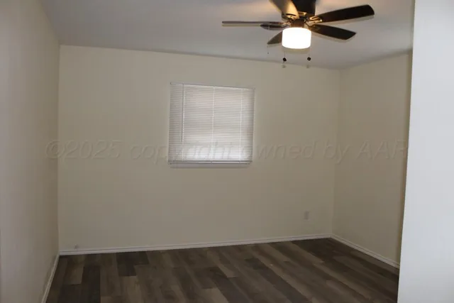 an empty room with a window and a fan