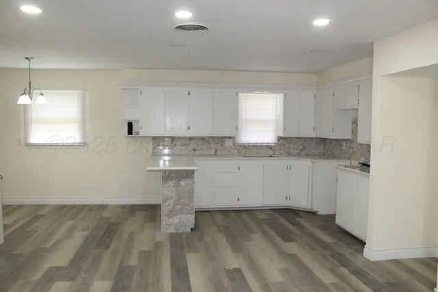 a view of a kitchen with white cabinets appliances and a window