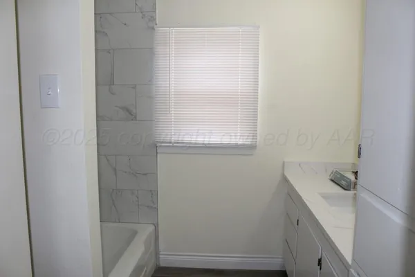 a bathroom with a bathtub sink and window