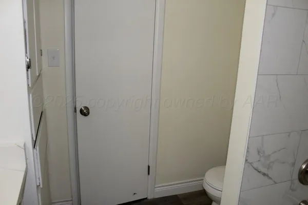 a white toilet sitting next to a shower