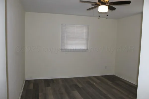 an empty room with a chandelier fan