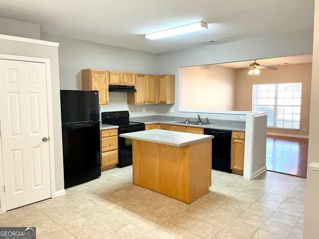 a kitchen with a refrigerator and a stove top oven