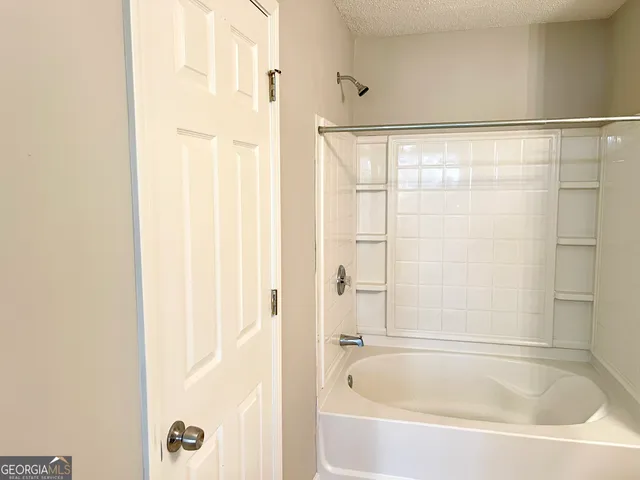 a white bath tub sitting next to a shower