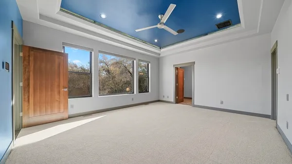 a view of an empty room with a window and chandelier