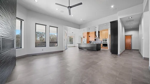 a view of an empty room with a fireplace and windows
