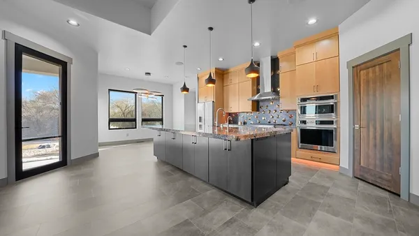 a kitchen with stainless steel appliances granite countertop a stove a sink and a refrigerator
