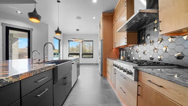 a large kitchen with stainless steel appliances granite countertop a stove and a sink