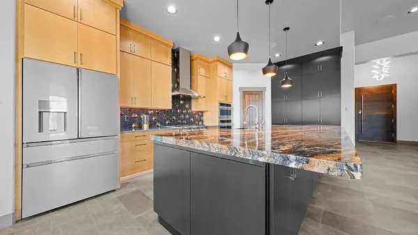 a kitchen with stainless steel appliances granite countertop a refrigerator a oven and a sink with granite countertops