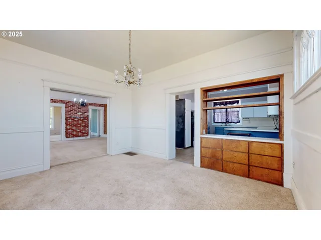 a kitchen with a sink a stove a window cabinets and a dining table