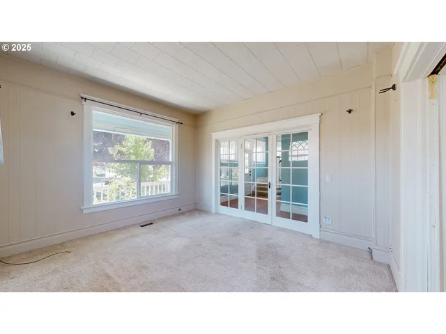a open hall with a floor to ceiling window and a living room