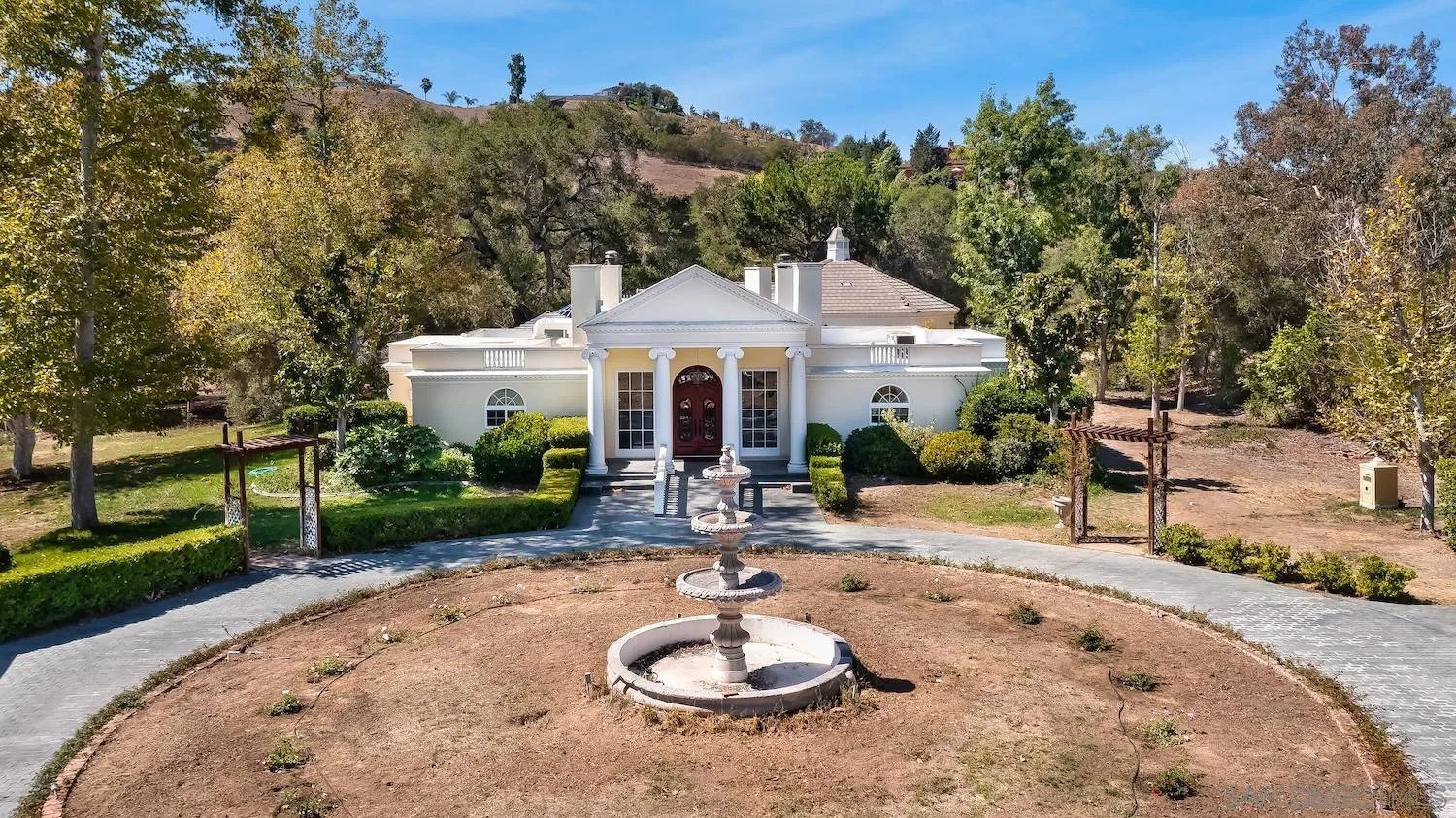 4735 Olive Hill Road Fallbrook, CA 92028 - Photo 1 of 22 a patio with a table and chairs under an umbrella