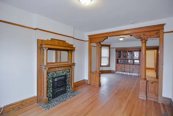 a view of a livingroom with wooden floor and a fireplace