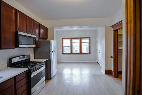 a kitchen with granite countertop wooden floors and stainless steel appliances