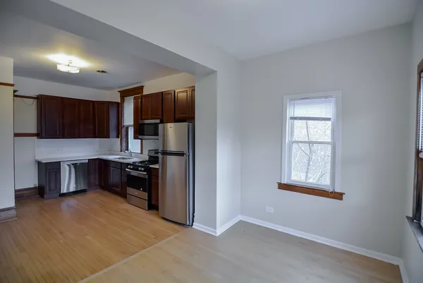 a kitchen with granite countertop a refrigerator and a stove top oven