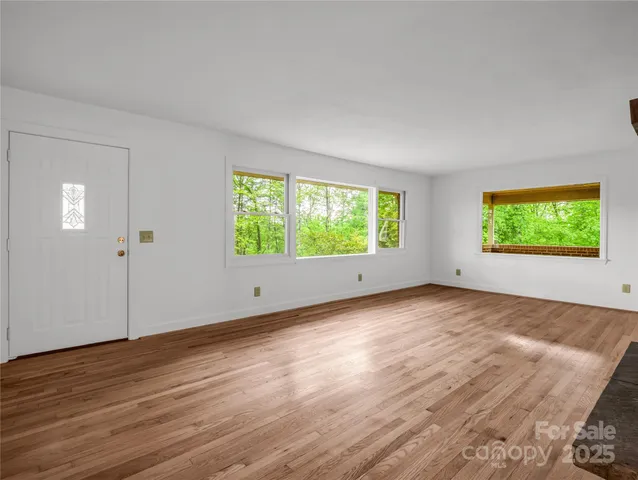 a view of empty room with wooden floor and fireplace