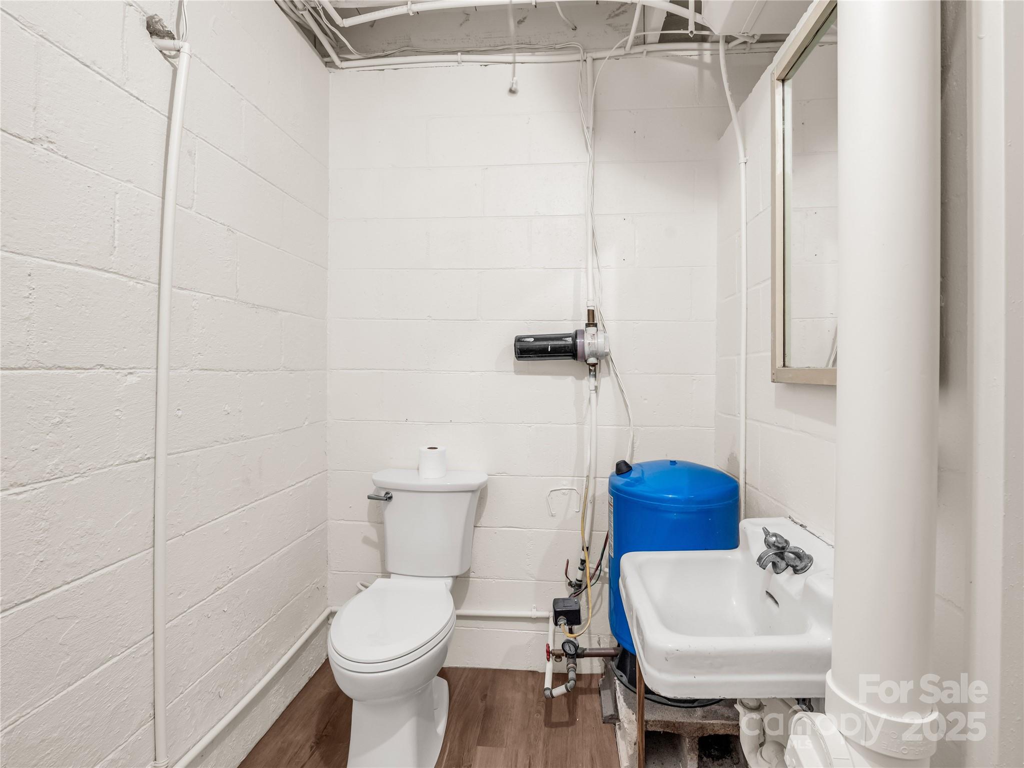 200 Little Wings Mountain Road Columbus, NC 28722 - Photo 29 of 42 a bathroom with a toilet sink and mirror