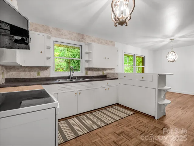a kitchen with a stove and white cabinets