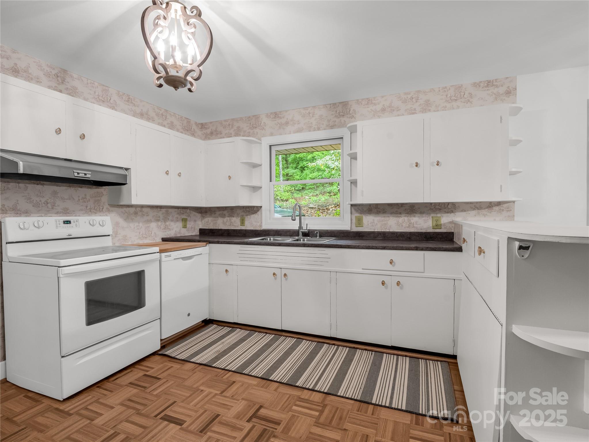 200 Little Wings Mountain Road Columbus, NC 28722 - Photo 6 of 42 a kitchen with a stove and white cabinets