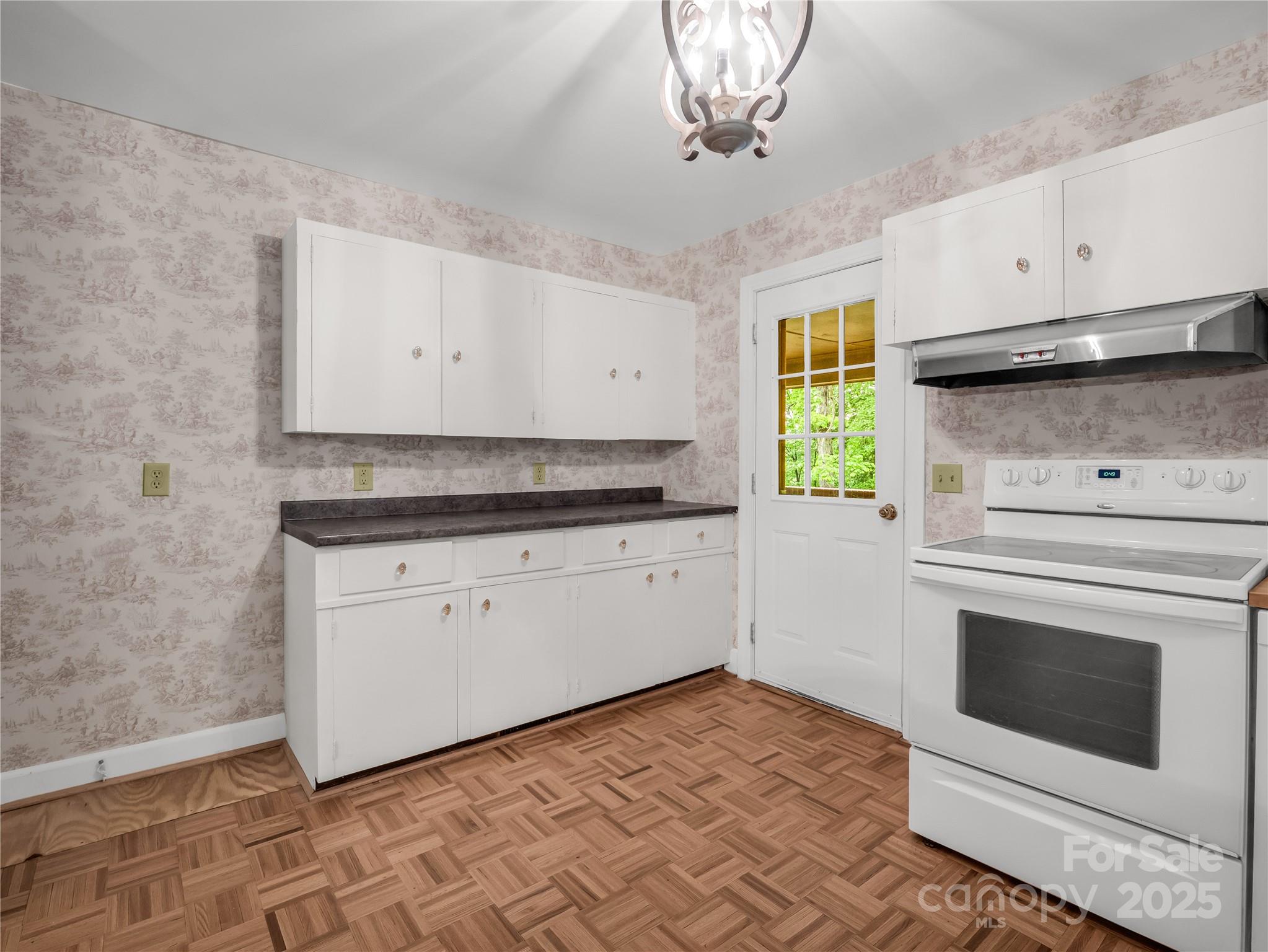 200 Little Wings Mountain Road Columbus, NC 28722 - Photo 7 of 42 a kitchen with a stove and white cabinets