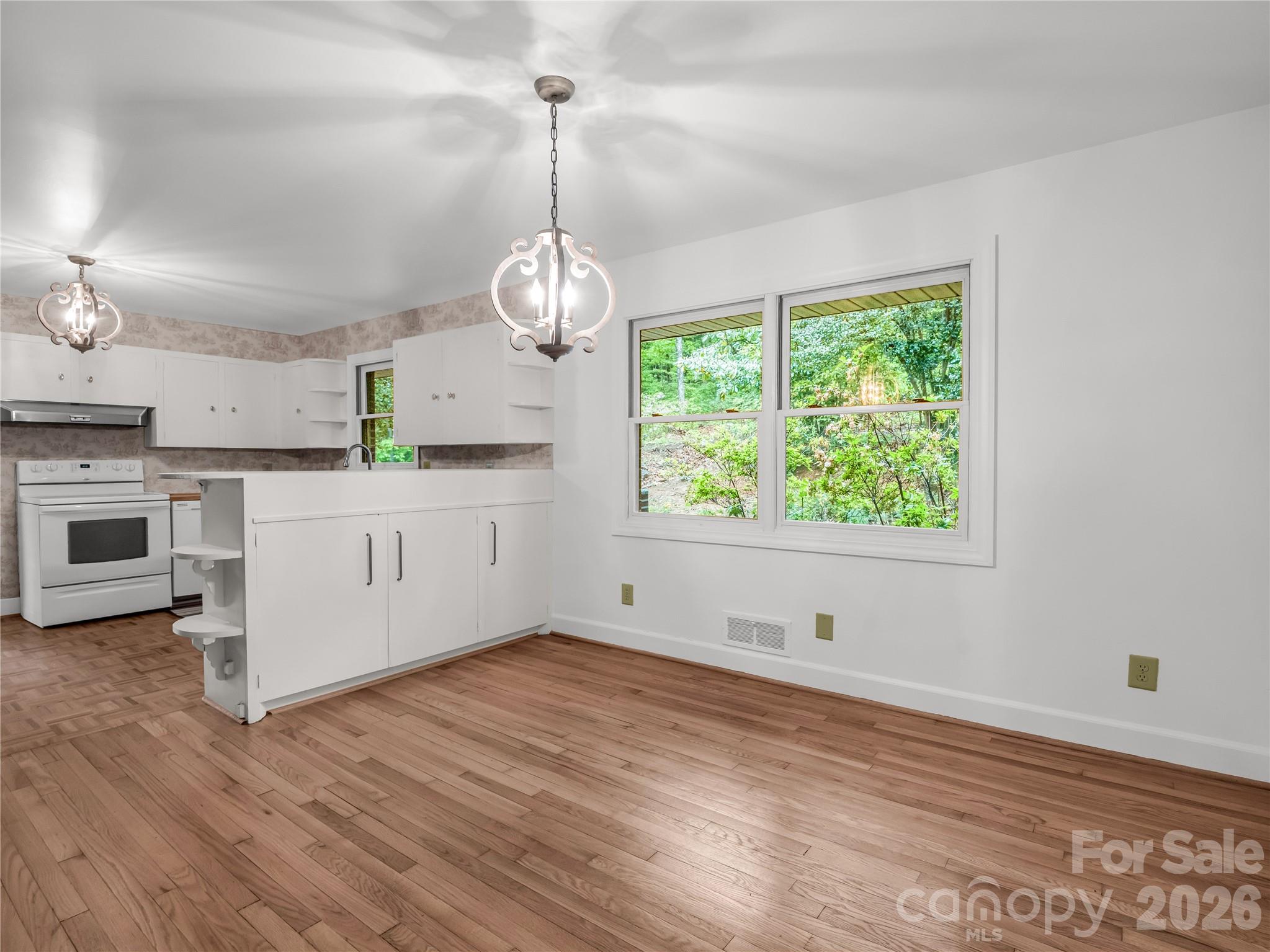 200 Little Wings Mountain Road Columbus, NC 28722 - Photo 10 of 42 a kitchen with stainless steel appliances granite countertop a stove and a wooden floors