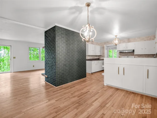 an empty room with windows and fireplace