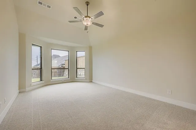 an empty room with chandelier fan