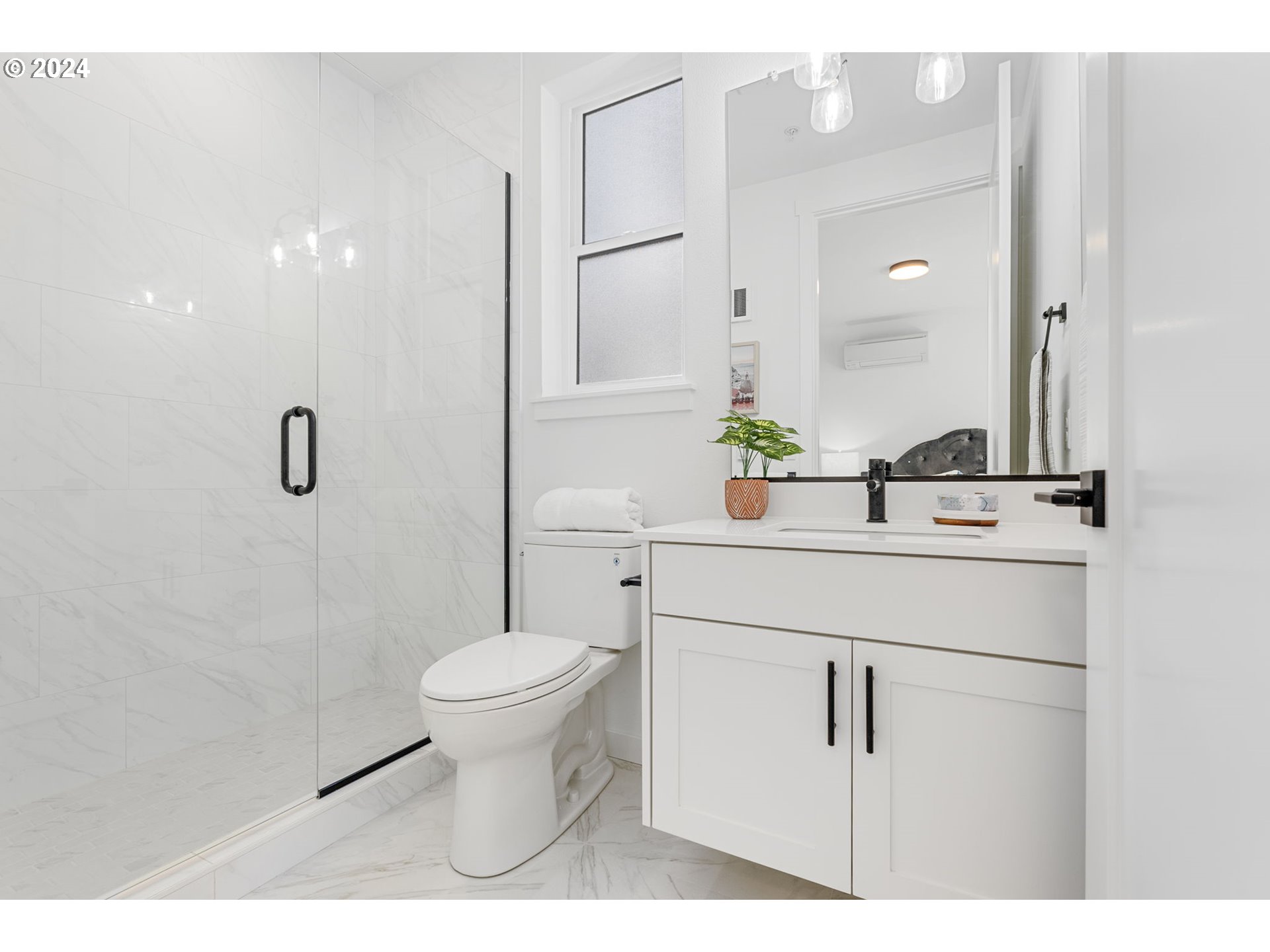 121 North Going Street, Unit 202 Portland, OR 97217 - Photo 22 of 30 a bathroom with a sink a toilet a mirror and shower