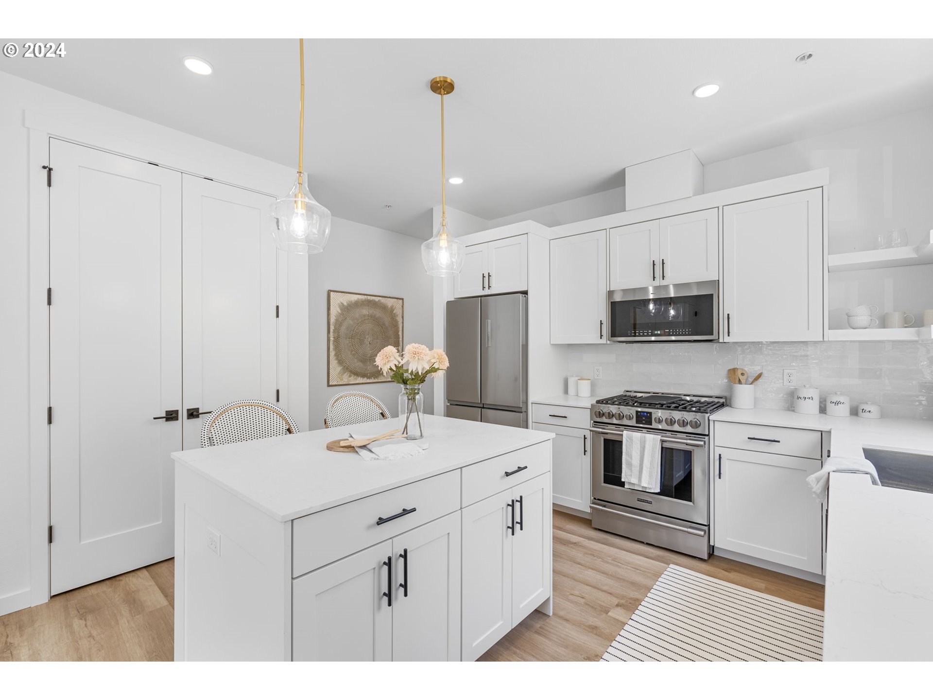 121 North Going Street, Unit 202 Portland, OR 97217 - Photo 3 of 30 a kitchen with stainless steel appliances kitchen island granite countertop a sink stove and white cabinets with wooden floor
