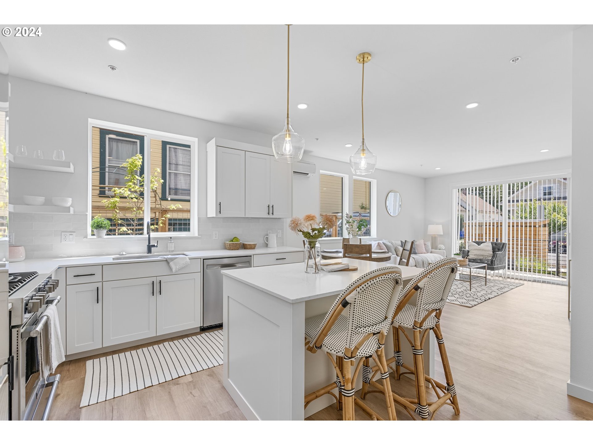 121 North Going Street, Unit 202 Portland, OR 97217 - Photo 4 of 30 a open kitchen with stainless steel appliances granite countertop a stove a sink dishwasher a dining table and chairs with wooden floor