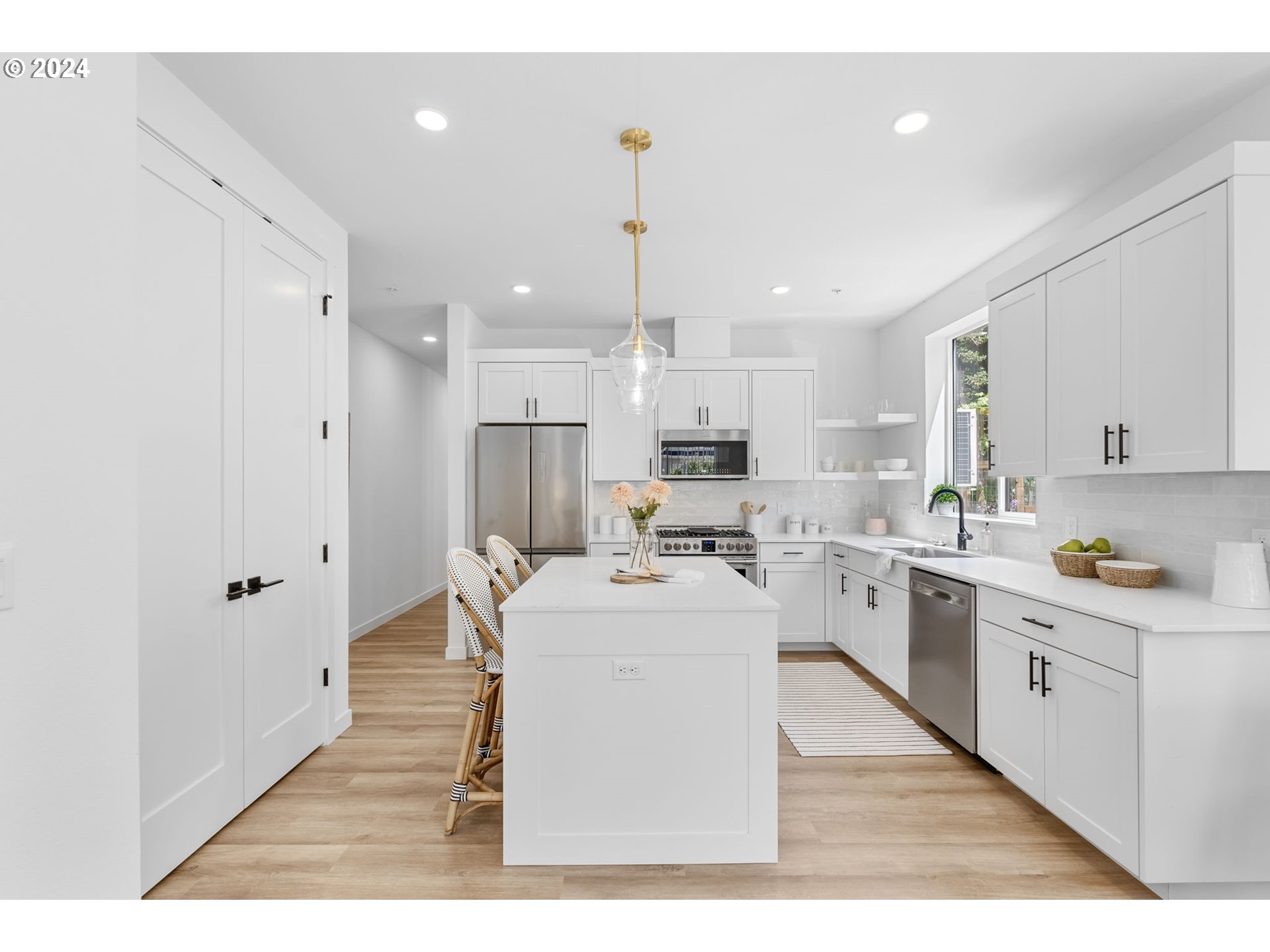 121 North Going Street, Unit 202 Portland, OR 97217 - Photo 8 of 30 a open kitchen with white cabinets and stainless steel appliances