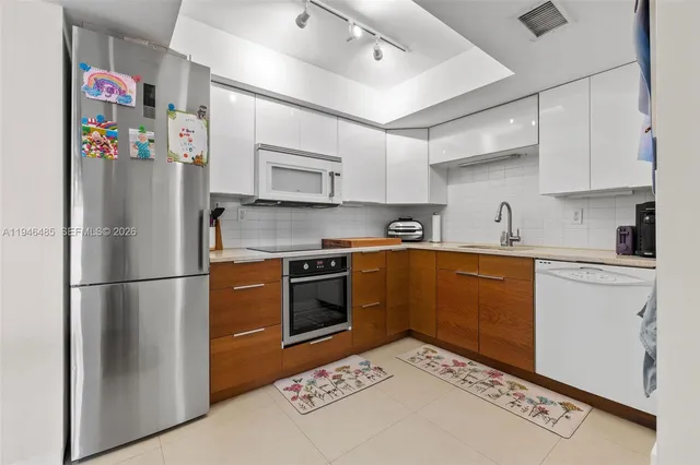 a kitchen with stainless steel appliances granite countertop a refrigerator sink and stove