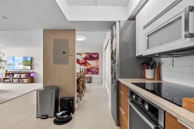 a kitchen with stainless steel appliances granite countertop a sink and a refrigerator