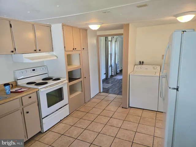 a kitchen with a stove a refrigerator and cabinets