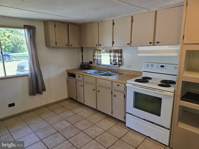 a kitchen with a stove sink and cabinets
