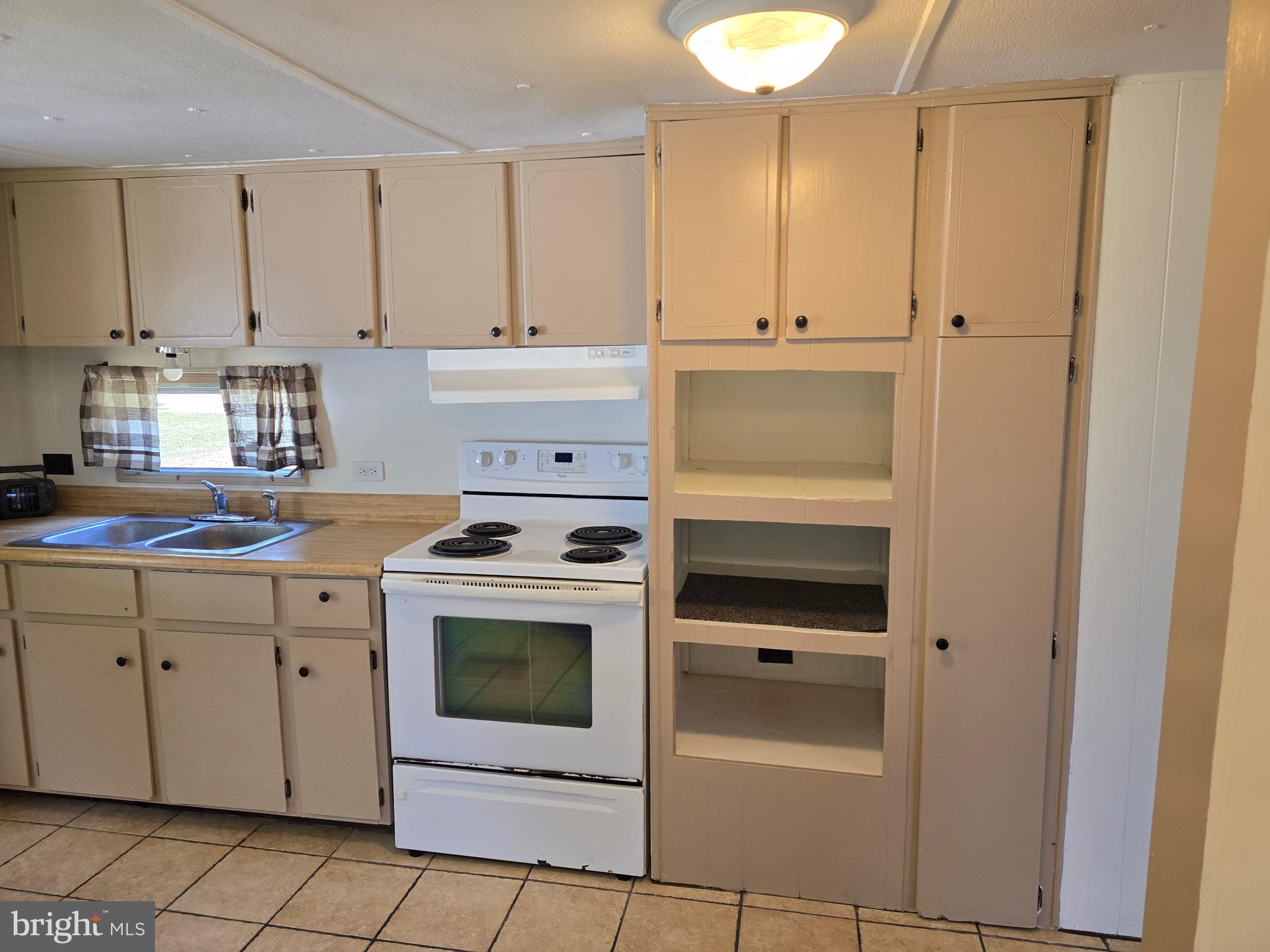 4662 Powellville Road Pittsville, MD 21850 - Photo 29 of 34 a kitchen with white cabinets and white appliances