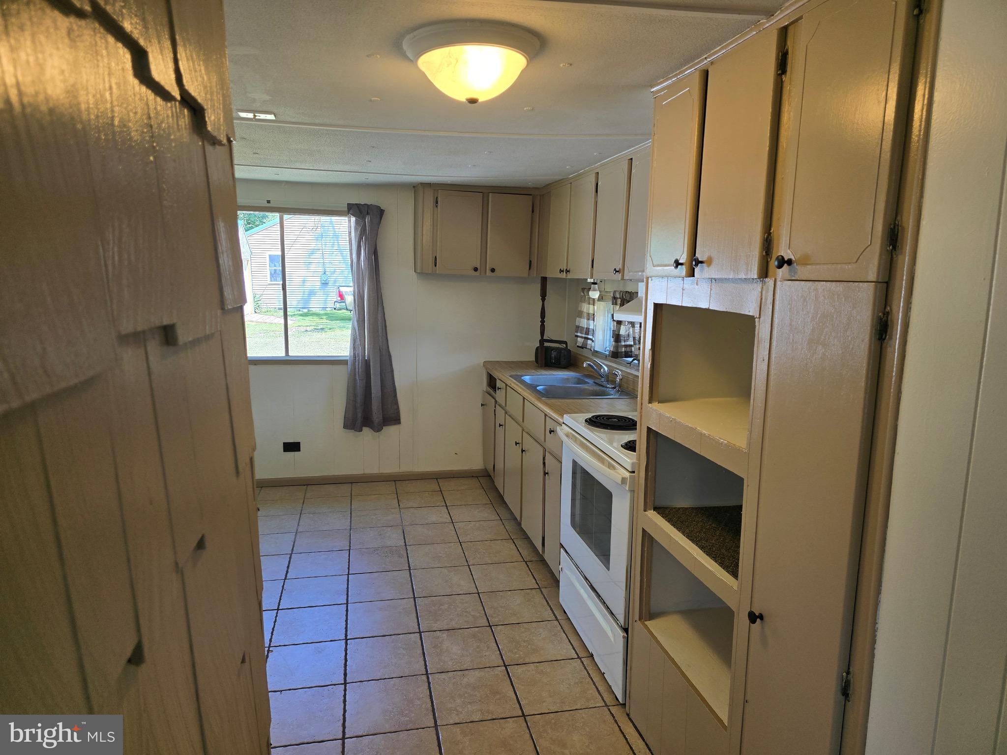 4662 Powellville Road Pittsville, MD 21850 - Photo 30 of 34 a kitchen with a sink a refrigerator and cabinets