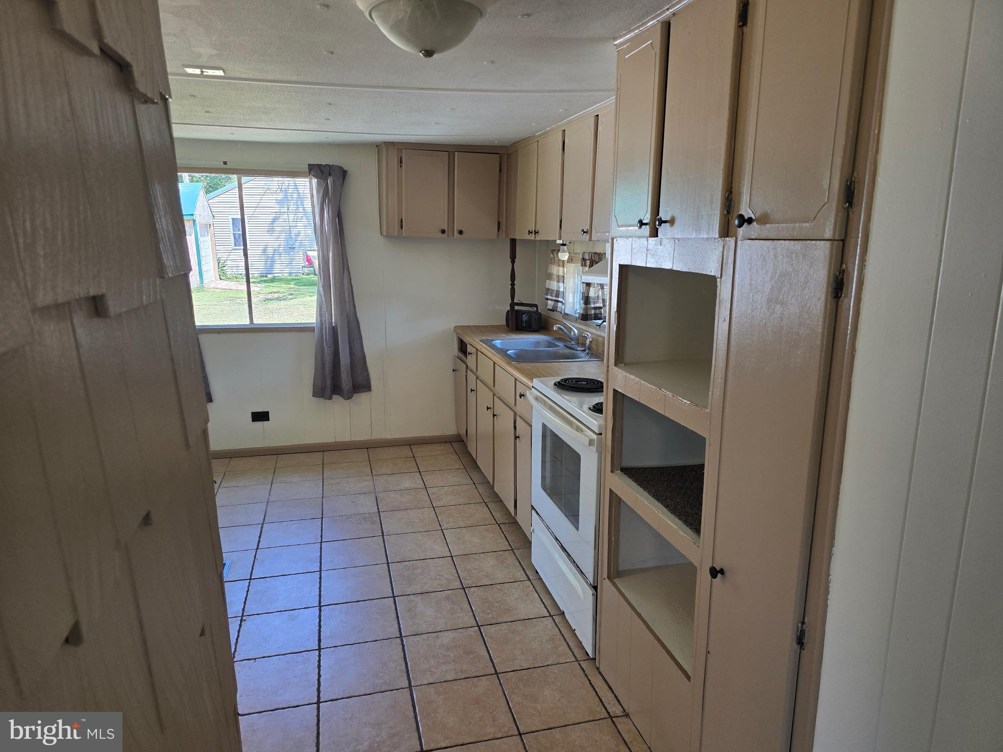 4662 Powellville Road Pittsville, MD 21850 - Photo 31 of 34 a kitchen with a stove a sink and a refrigerator