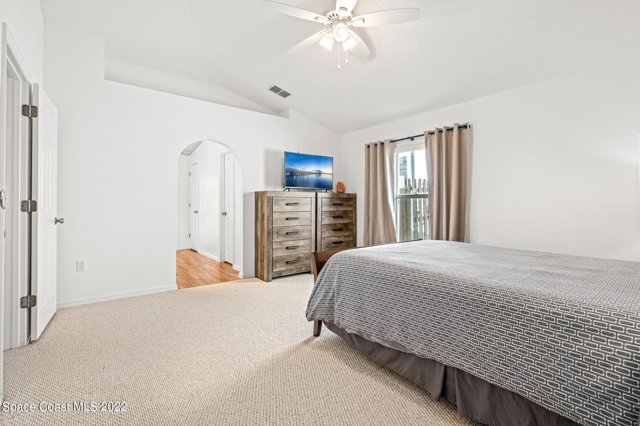 1920 Brookshire Circle Melbourne, FL 32904 - Photo 23 of 41 a bedroom with a bed and a chandelier