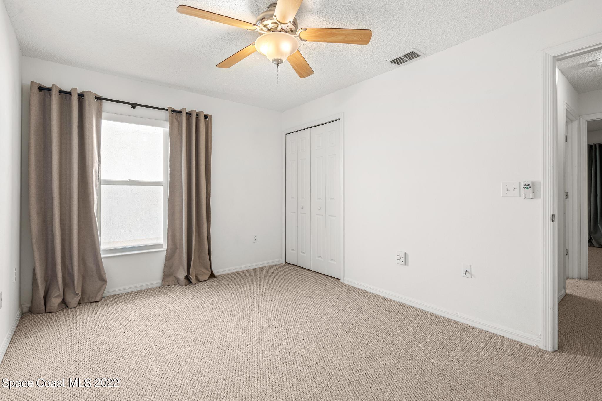 1920 Brookshire Circle Melbourne, FL 32904 - Photo 24 of 41 an empty room with windows and fan