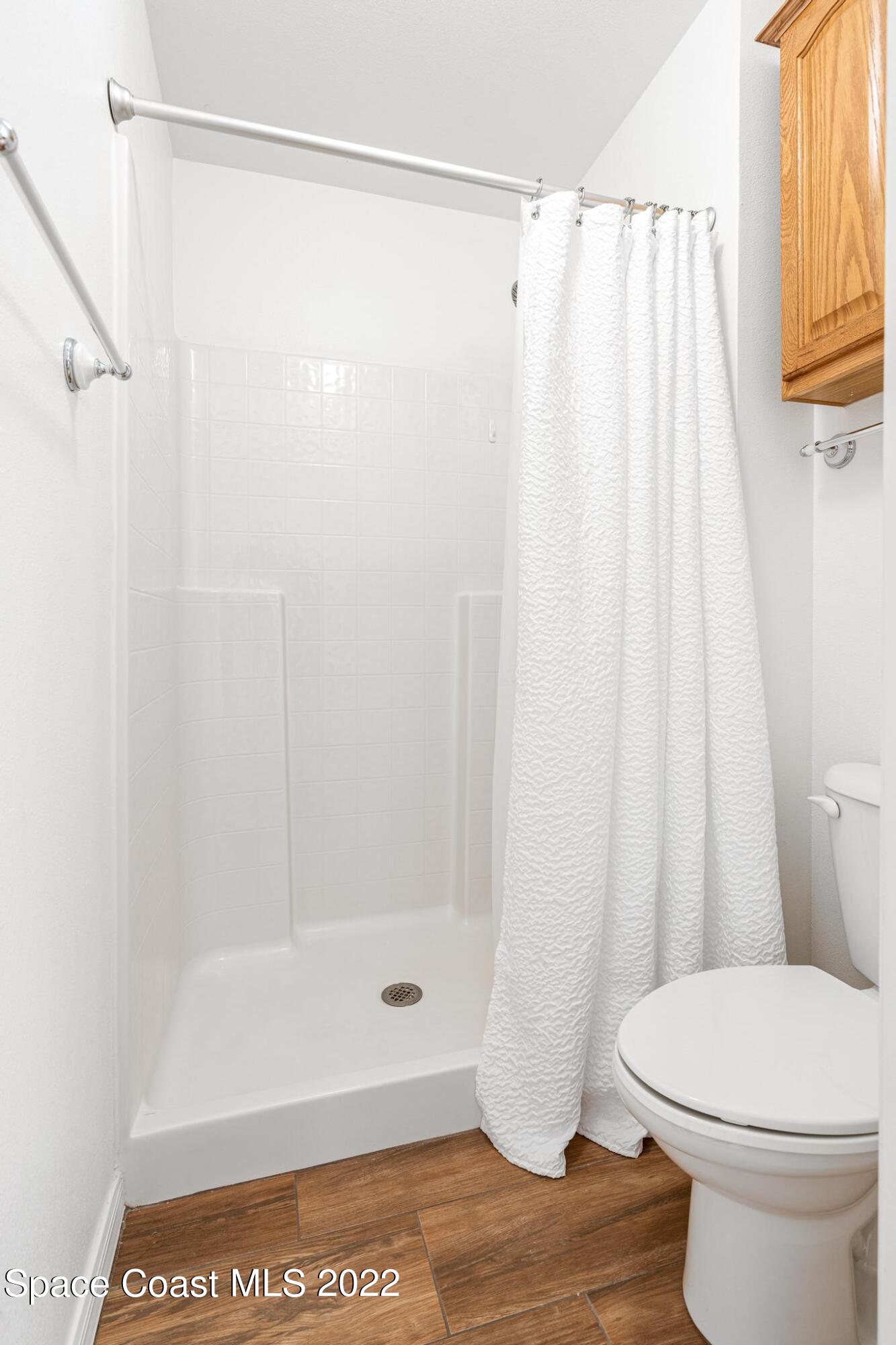 1920 Brookshire Circle Melbourne, FL 32904 - Photo 27 of 41 a bathroom with a shower curtain and a toilet