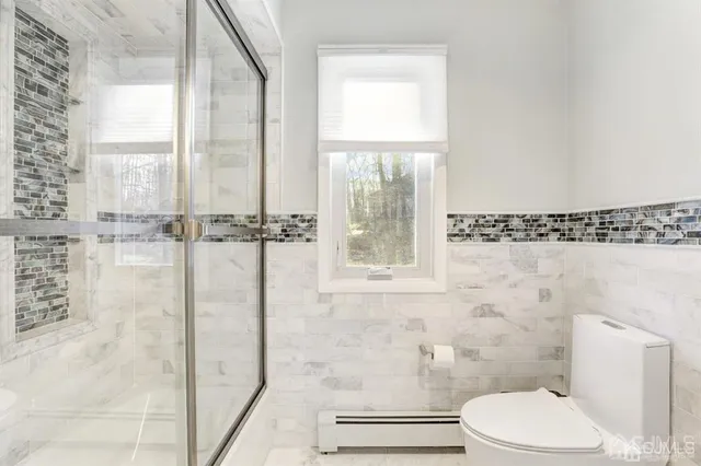 a bathroom with a toilet and a shower