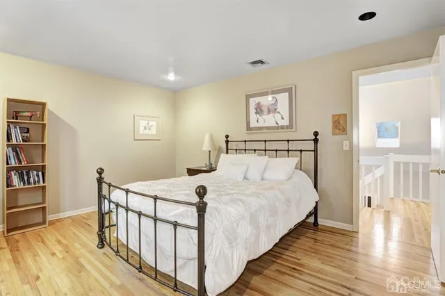 a bedroom with a bed and a wooden floor