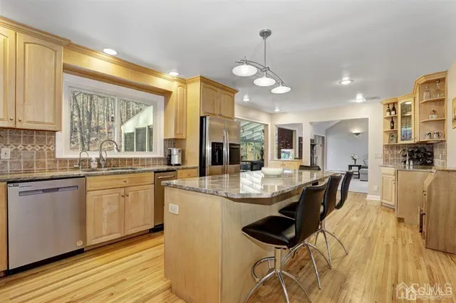 a kitchen with stainless steel appliances kitchen island granite countertop a sink and cabinets