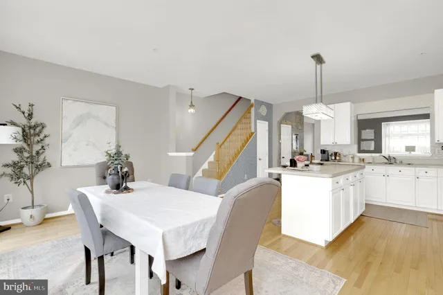 a view of a kitchen with kitchen island a stove a refrigerator a sink dishwasher with a dining table and chairs