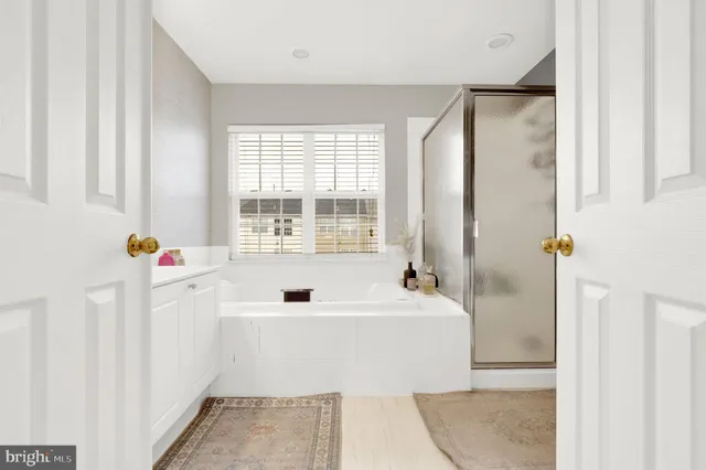 a bathroom with a tub sink and mirror