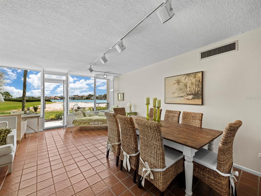 100 Sands Point Road, Unit 108 Longboat Key, FL 34228 - Photo 12 of 46 a dining room with furniture and a floor to ceiling window