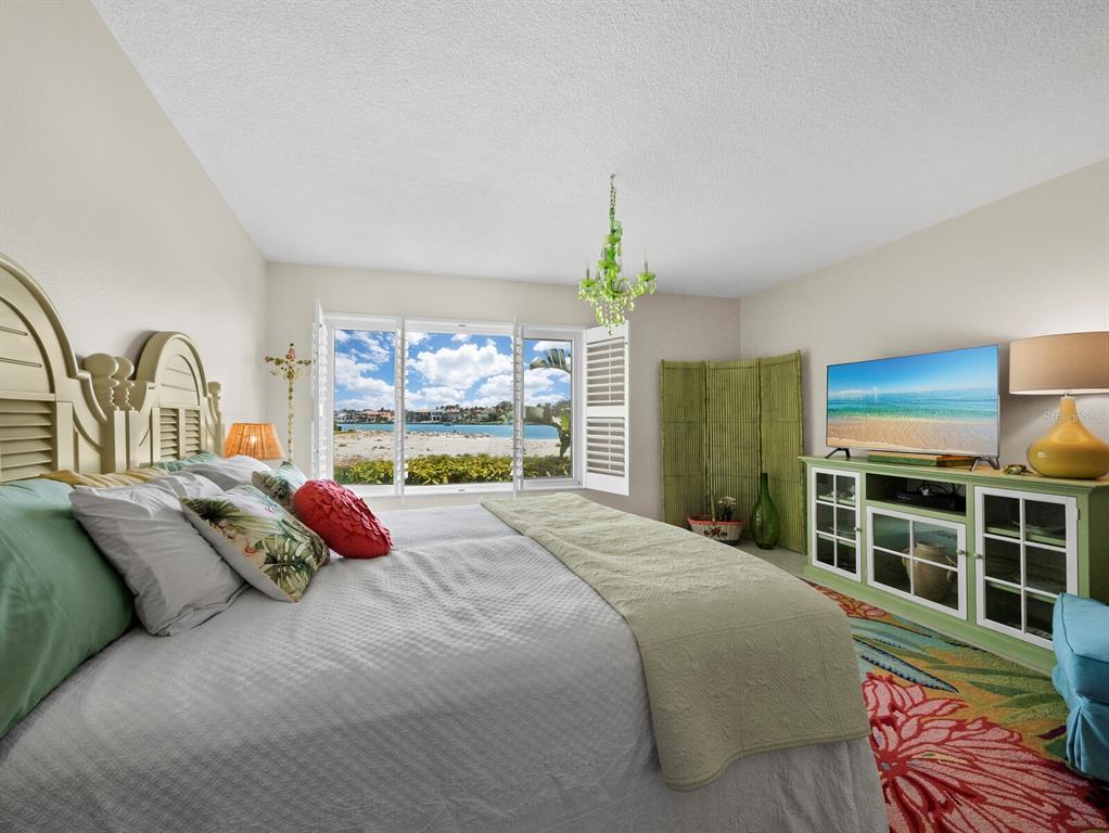 100 Sands Point Road, Unit 108 Longboat Key, FL 34228 - Photo 21 of 46 a bed sitting in a bedroom next to a window