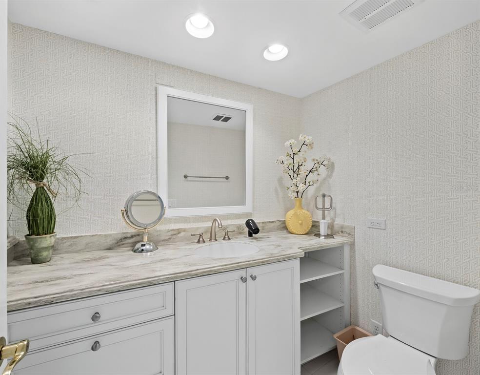 100 Sands Point Road, Unit 108 Longboat Key, FL 34228 - Photo 24 of 46 a bathroom with a granite countertop sink a toilet and mirror