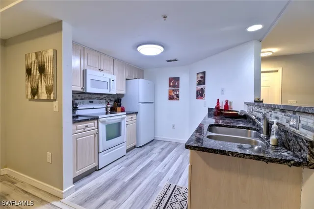 a kitchen with stainless steel appliances granite countertop a stove a sink and a refrigerator